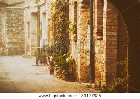 Empty street of small Tuscany town San Quirico d'Orcia in the morning fog, romantic travel vintage hipster european italy background