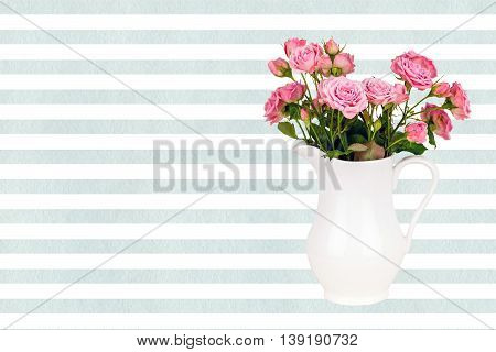 Pink flowers in white jug on watercolor blue stripes background. Roses in jug on LightCyan watercolor striped background. Background with flowers. Background with pink roses.