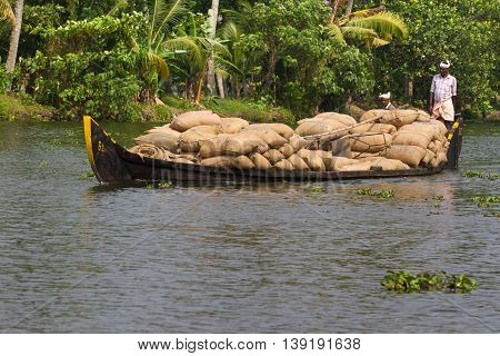 Allepey Kerala India March 31 2015: Indian man transport dwell on boats. Backwaters canoe