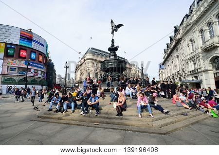 PICCADILLY CIRCUS London - June 06, 2014: People enjoying the sun at Piccadilly Circus London