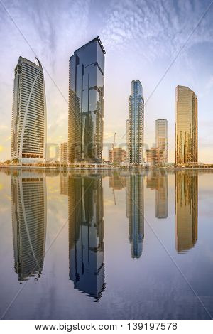 Panoramic view of Business bay and Lake Tower, reflection in a river, Dubai UAE.