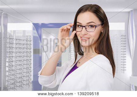 Portrait of young businesswoman smiling in eyeglasses at optik store