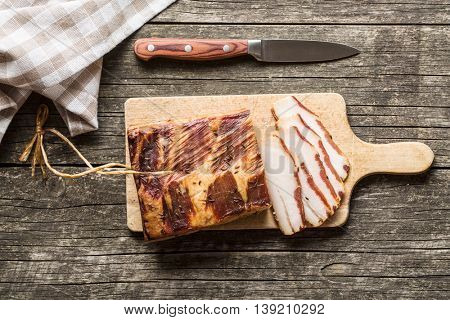Fresh smooked bacon on old wooden table.