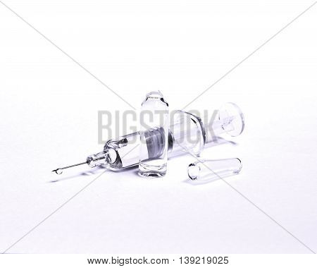 Medicine vials ampoules and syringe on white background