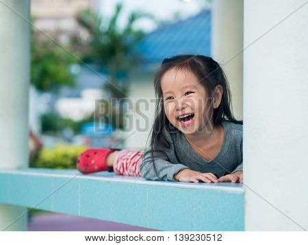 Adorable little girl playing peekaboo asian child