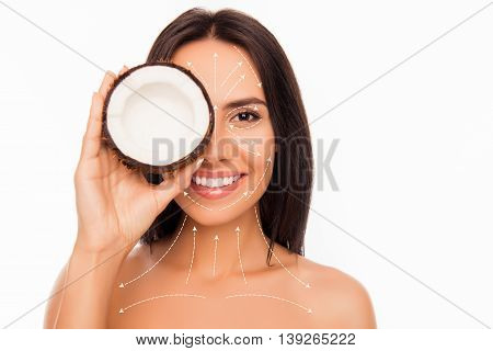 Cheerful Smiling Pretty Young Woman Holdind Coconut Near Her Face With Arrows