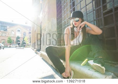 A beautiful young Hip Hop Rapper girl with Headphones in a urban environment.