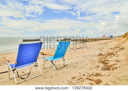 A day at Edisto Beach in South Carolina with vacationers marking their area with beach chairs, umbrellas, etc.