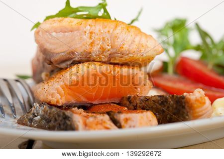 close up image of grilled samon filet with vegetables salad