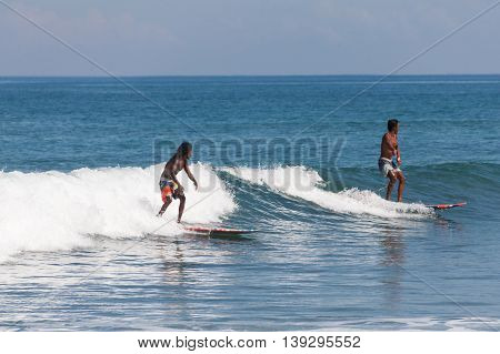 BALI, INDONESIA, 8 April 2016: Surfing in Kuta. Kuta is a beach and resort area in the south of the island of Bali, Indonesia. One of Bali's first tourist developments, it's best known for its Indian Ocean surfing and party-centric atmosphere.