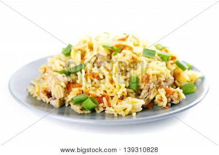 Fragrant Pilau Pulav pilaf pilaf, fried rice with meat and vegetables on a grey plate. Isolated on white. Macro.