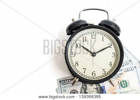 Selective focus top view of black vintage antique alarm clock on dollar money cash isolated on white background - concept of time and financial management