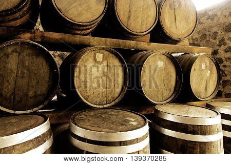 Wine barrels stacked in the old cellar of the winery.