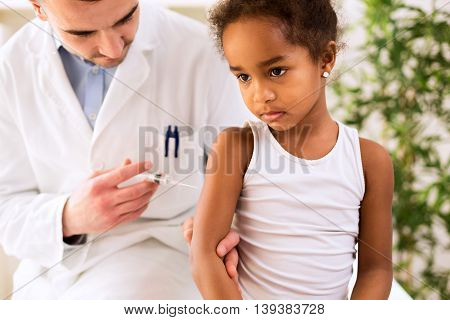 Medical Doctor Injecting A Vaccine Into The Arm Of A Patient