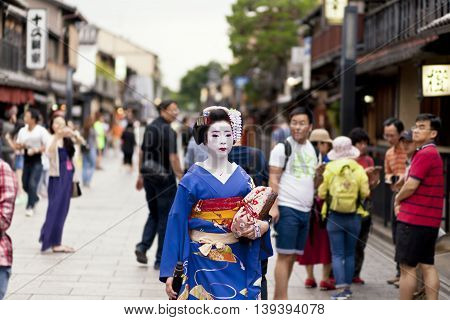 KYOTO, JAPAN - MAY 26,2016: Maiko in kimono performs in Gion district on May 26, 2016 in Kyoto, Japan. Maiko is a geisha apprentice, left from the medieval times.