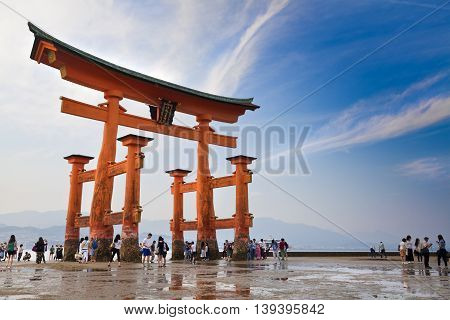 MIYAJIMA, JAPAN - MAY 27: Tourists walk around the famous floating torii gate of the Itsukushima Shrine on Miyajima at sunset on May 27,2016 in Miyajima, Japan