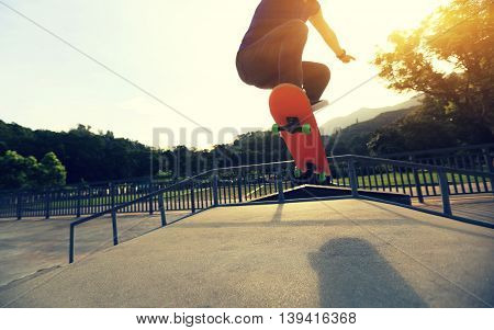 one young skateboarder skateboarding at sunrise skatepark