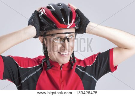 Safety Concept and Ideas. Male Caucasian Cyclist Checking Road Helmet. Wearing Glasses. Against White Background. Horizontal Image