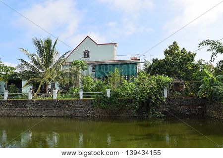 Vietnamese countryside with house next to the fishing pond