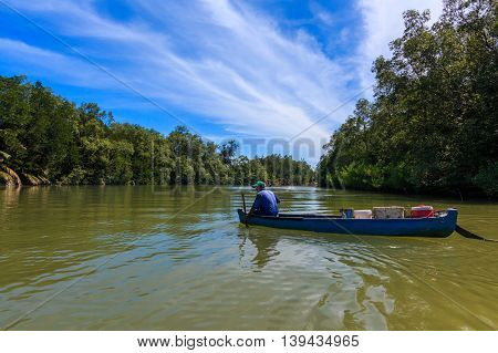 Tuaran, Sabah, Malaysia - May 28, 2016 : Fisherman riding on old boat at Mangrove Forrest river Image has grain or blurry and soft focus when view at full resolution. (Shallow DOF, slight motion blur)