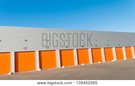 ENSCHEDE, NETHERLANDS - NOVEMBER 28, 2015: Exterior of a commercial warehouse with orange roller doors