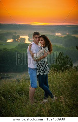 romantic couple at sunset on bright yellow sky background, love tenderness concept, young adult people