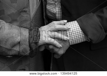Hands. Close-up.Old man and old woman holding hands. True love. Black and white.