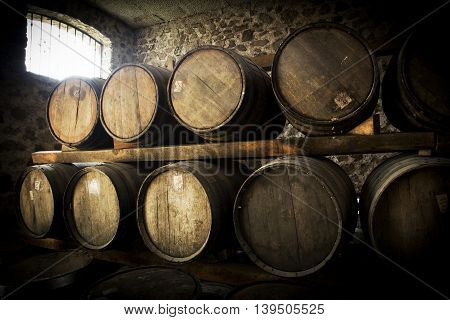 Wine barrels stacked in the old cellar of the winery.