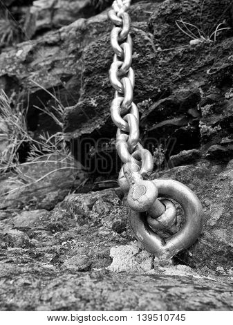 Steel Bolt Anchor Eye In Hard Basalt Rock. End Of Steel Chain