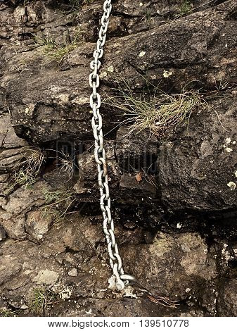 Steel Bolt Anchor Eye In Hard Basalt Rock. End Of Steel Chain