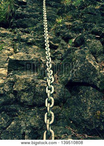 Detail Of Chain Anchored In Hard Whinstone Rock. Climbers Path