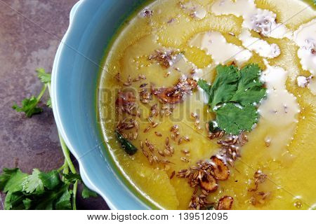 Yellow Lentil soup or Arhar Daal fry with the tadka of cumin seeds garlic and green chilies on a moody background