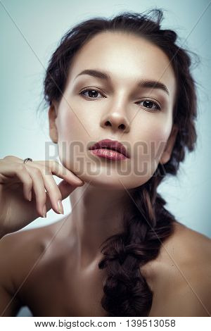 Fashion portrait of gorgeous young brunetee woman.Chaos hair style with braid. Shallow depth of field