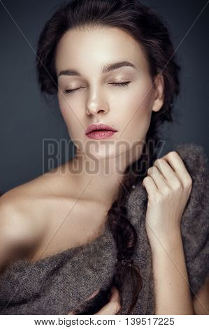 Fashion portrait of gorgeous young brunetee woman.Chaos hair style with braid. Shallow depth of field