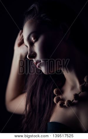 Fashion portrait of gorgeous young brunetee woman. Shallow depth of field. Low key portrait on black