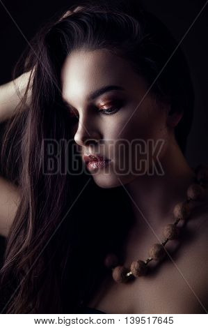 Fashion portrait of gorgeous young brunetee woman. Shallow depth of field. Low key portrait on black