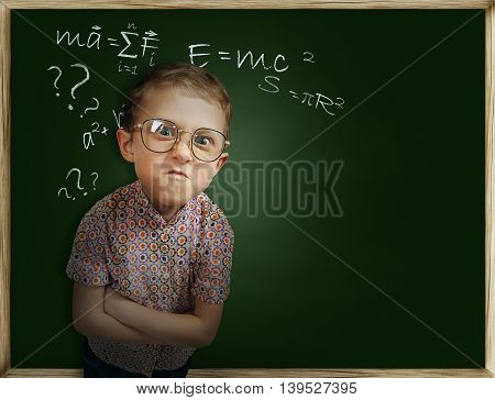 Emotional frowning pupil boy near chalkboard unhappy to go back to school
