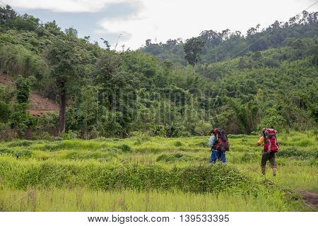 Man Traveler with big backpack mountaineering Travel to the Pre To Lo Su or Pi Tu Kro waterfall heart-shaped waterfall Umphang Tak ,Thailand.