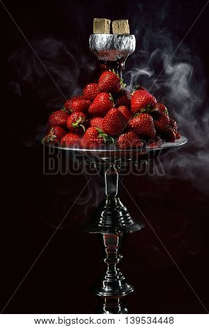 Smoking hookah with fruit head on dark background