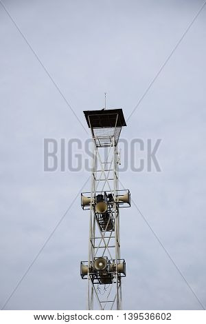 A Loudspeakers broadcast tower on sky background.