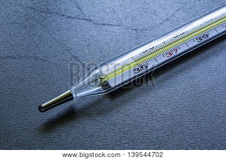 Medical Glass Mercury Thermometer On A Black Steel Background
