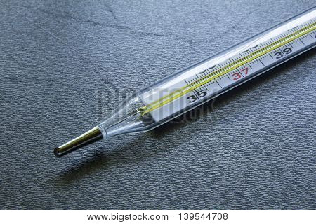 Medical Glass Mercury Thermometer On A Black Steel Background