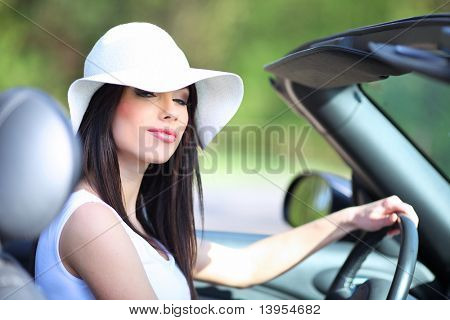 Retrato de mujer de verano hermoso en el coche cabrio