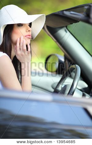 Retrato de mujer de verano hermoso en el coche cabrio