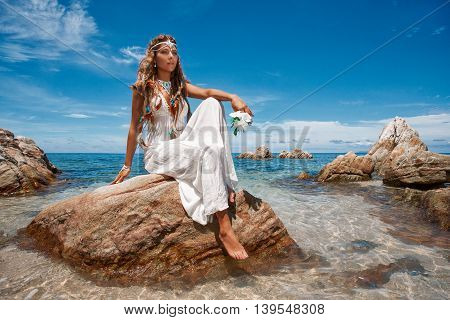 Beautiful young bride in white wedding dress on beach
