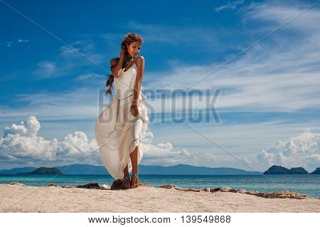 beautiful young woman in white dress on the beach