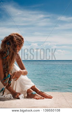 closeup photo of beautiful young bride legs with anklets. holding flower in her arms.