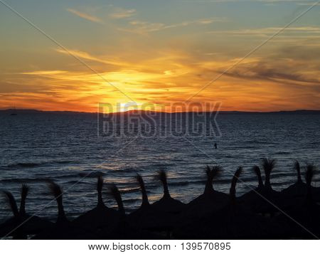 Lone fisherman fishing in the mediterranean sea off the coast near Marbella Spain at sunset