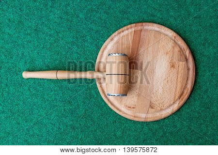 Wooden kitchen hammer and cutting board on a green background