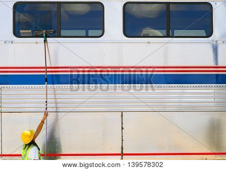 ALBUQUERQUE, USA - MAY 24, 2015: A worker is cleaning the windows of a bilevel car of the Amtrak passenger train Southwest Chief at the station.